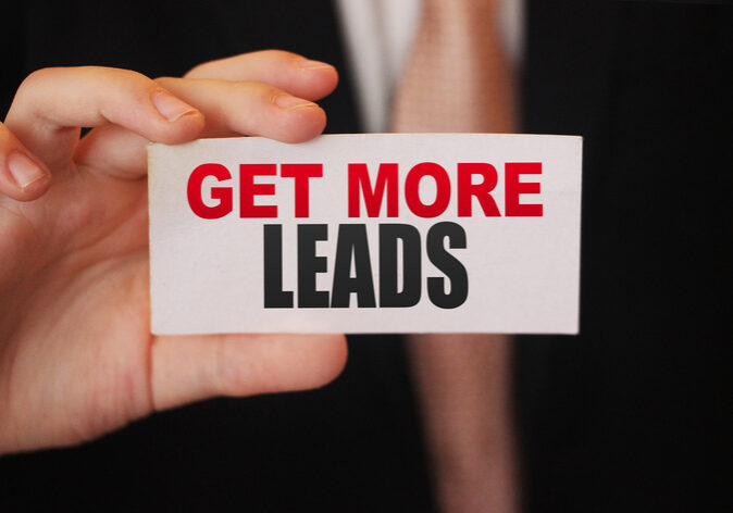 Businessman holding a card with text Get more leads. Business concept.