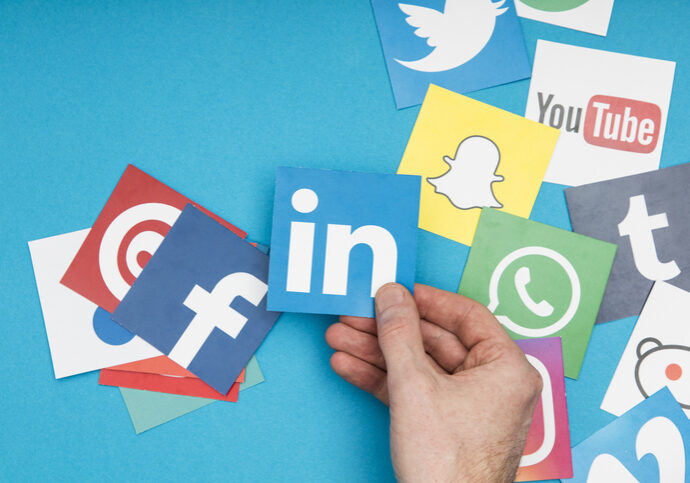 London, United Kingdom - September 6, 2016: A male hand interacting with a collection of popular social media logos.